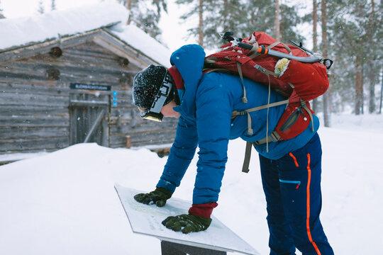 Female Backpacker Checking Map Along Snowy Trail