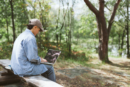 Young woman with laptop sitting on bench
