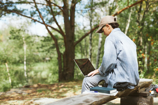 Young woman with laptop sitting on bench