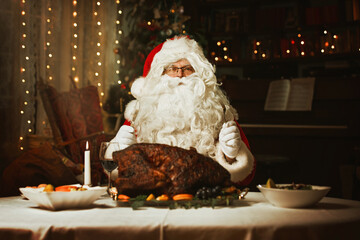Santa Claus sitting at a table, eating a turkey