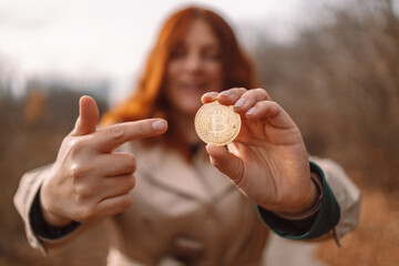 Golden bitcoin in a business woman hand outdoors. Cryptocurrency concept