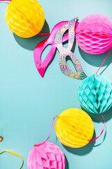 Carnival mask and confetti on a blue background. The concept of a traditional venetian carnival in...
