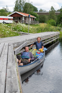 Smiling men in rowing boat