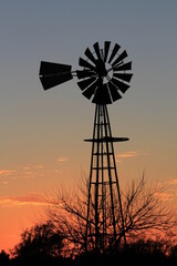 windmill at sunset with a colorful sky out in the country north of Hutchinson Kansas USA.