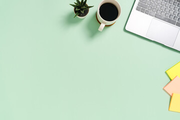 Minimal work space - Creative flat lay photo of workspace desk. Top view office desk with laptop and coffee cup on pastel green color background. Top view with copy space, flat lay photography.