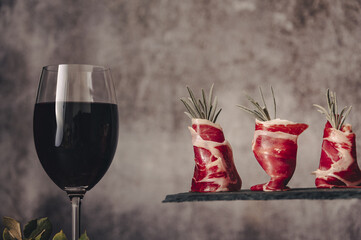 Plate of delicious Iberian ham on a wooden table background. Appetizing slices Iberian ham. Acorn-fed Iberico Ham. Pata negra, spectacular vision of sliced ham. Typical spanish food.