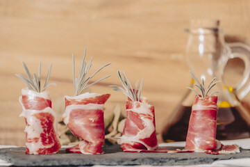 Plate of delicious Iberian ham on a wooden table background. Appetizing slices Iberian ham. Acorn-fed Iberico Ham. Pata negra, spectacular vision of sliced ham. Typical spanish food.
