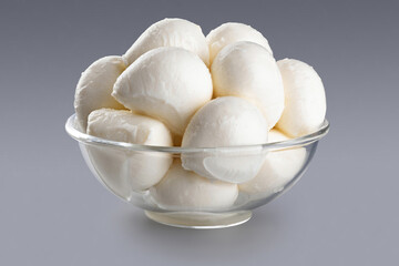 Bowl with mozzarella cheese on gray background. With clipping path.