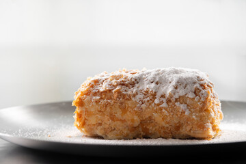 Napoleon cake with icing sugar  . Decorating napoleon cake with powdered sugar.