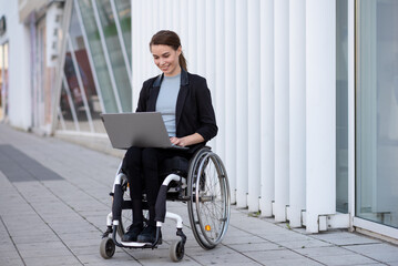 Disabled businesswoman in a wheelchair working outside - obrazy, fototapety, plakaty