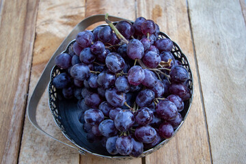 black ripe grapes in a metal vase