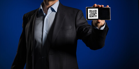 QR code on the smartphone screen, which is held in the hands of a man. The concept of mandatory...