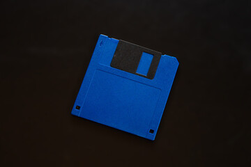 blue floppy disk lies on a black background