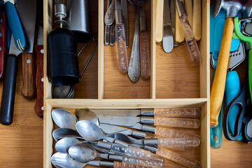 Cutlery tray in drawer of kitchen table, with division into compartments.