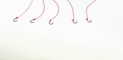 Fishing hook, red rope on white background, with empty space.