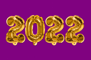 Golden foil balloons made numbers 2022 on a violet background. New Year's card. Happy new year celebration party. Greetings and congratulation concept.