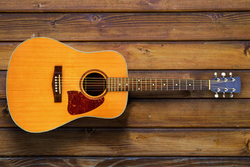 acoustic guitar on wooden surface in background