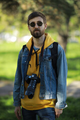 Cheerful guy with a camera in his hands and in sunglasses. Photographer.