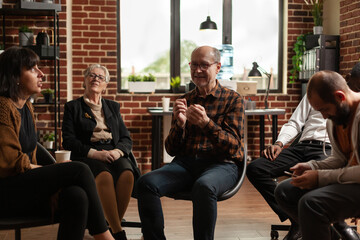 Senior man sharing addiction problems with group of people at aa meeting. Mental health patients receive counseling at support therapy session with psychiatrist. Community rehab program