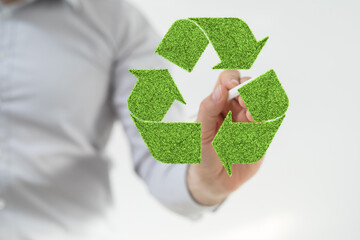 hand holding green recycle symbol