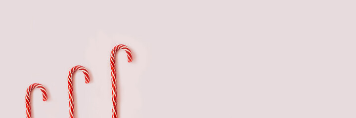 Fototapeta premium Christmas candy canes on pink background above.