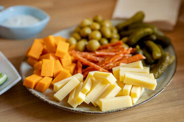 Plate with snacks cheese, sausages and pickles