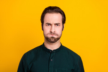 Photo of angry millennial guy grumpy wear green shirt isolated on yellow color background