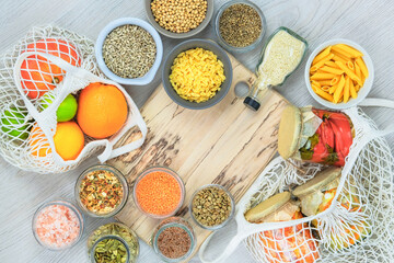 Healthy food nd balanced diet concept. Various farm organic products in glass jars on a light wooden background. Top view, copy space.