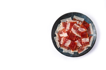 Spanish serrano ham slice on black plate isolated on white background
