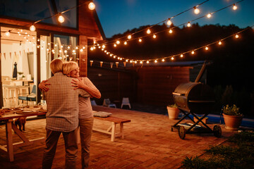 Lovely senior couple celebrating wedding anniversary with dancing.