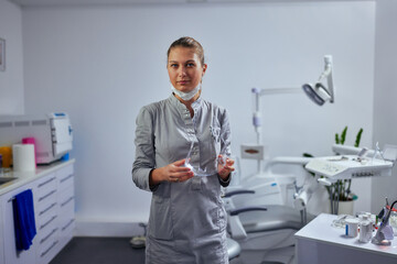 Naklejka na ściany i meble Portrait of a Caucasian female dentist in her office