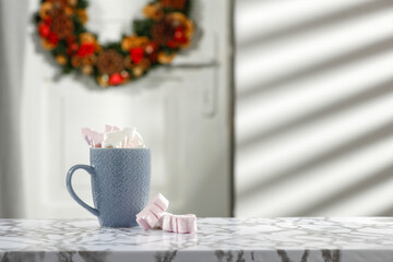 Christmas marshmallows in a cup on the table on a beautiful winter's day 
