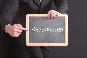 Geschäftsmann mit einer Tafel auf der Restposten steht