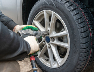 Service station worker is replacing a wheel.