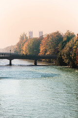 Munich, Bosch bridge on Isar river with the towers of St. Maximilian church, autumnal view in a sunny foggy day