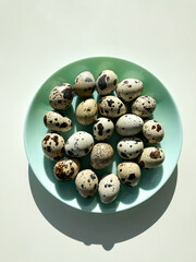 Quail eggs on the blue plate on the white table. Top view.