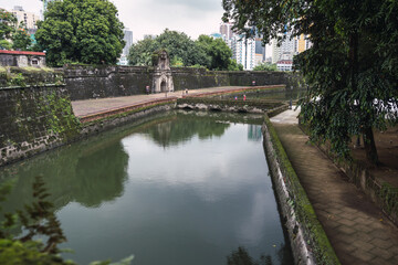 Fototapeta na wymiar water channel before a fortress on a cloudy day. Fort Santiago. Moriones Square. Tourist.