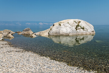Looking at the big stone which looks like a whale calf or a fish on Olkhon Island, Russia