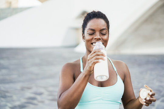 Fit african woman drinking water after workout sport routine - Focus on face