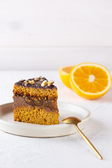 Piece of American pumpkin pie with orange on a light background. Sugar, gluten, lactose free.
