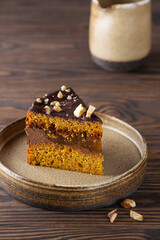 A slice of American pumpkin pie with orange on a brown wooden table. Sugar, gluten, lactose free.