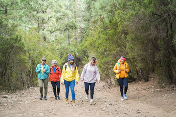 Multiracial women having fun during trekking day in mountain forest - Focus on african woman face