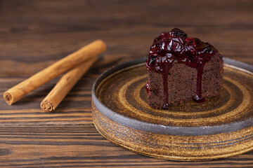 Chocolate brownie with black currant, eggplant and cinnamon on a brown wooden table. Sugar, gluten, lactose free, vegan.