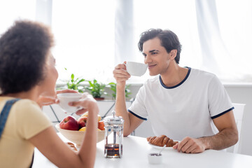 happy interracial couple drinking tea in morning