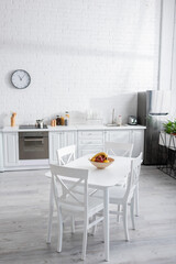 bowl with fruits on dining table in modern kitchen