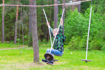 A boy overcomes a sports obstacle course in nature in the forest