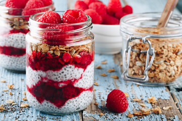 Chia Pudding. Healthy vanilla raspberry chia pudding in a glass jar with fresh berries and granola oats