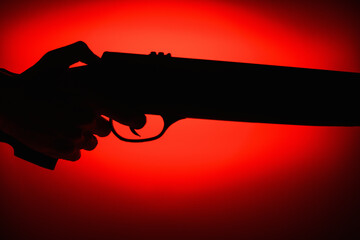 Silhouette of weapons in hands on a red and black background. Part of a rifle. Armed Forces Concept