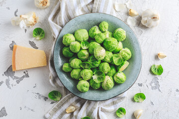 Raw Brussel sprouts with salt and Parmesan cheese in bowl