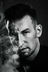 the brutal man in the black and white photo exhales thick smoke